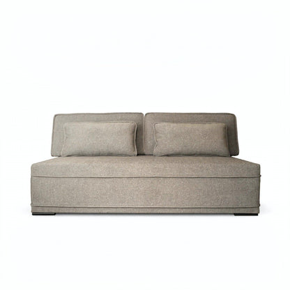 A modern low-profile loveseat sofa upholstered in a textured taupe fabric, featuring two matching square throw pillows, shown against a plain white background.