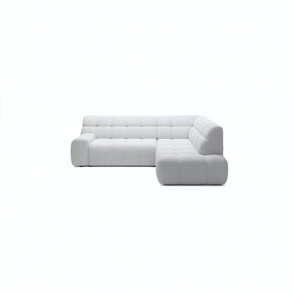 A light gray tufted modular sectional sofa with a right-facing chaise lounge, shown from a front-facing perspective against a solid white background.