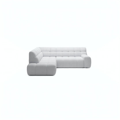 A light gray tufted modular sectional sofa with a left-facing chaise, shown from a front-facing perspective on a solid white background.