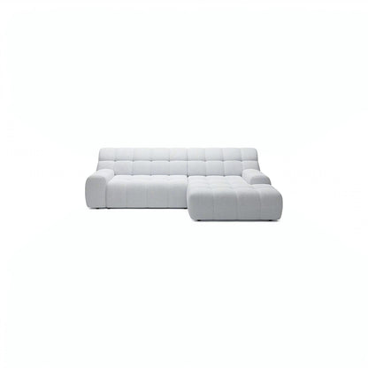 A modern light gray tufted sectional sofa with a right-facing chaise lounge, shown against a solid white background.