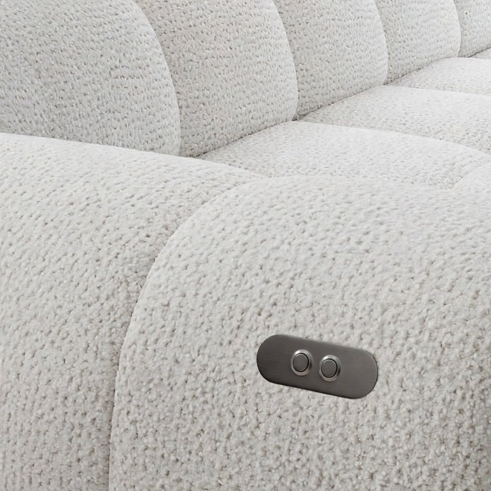 Close-up of a light grey textured sofa armrest featuring a metallic control panel for seat adjustment.
